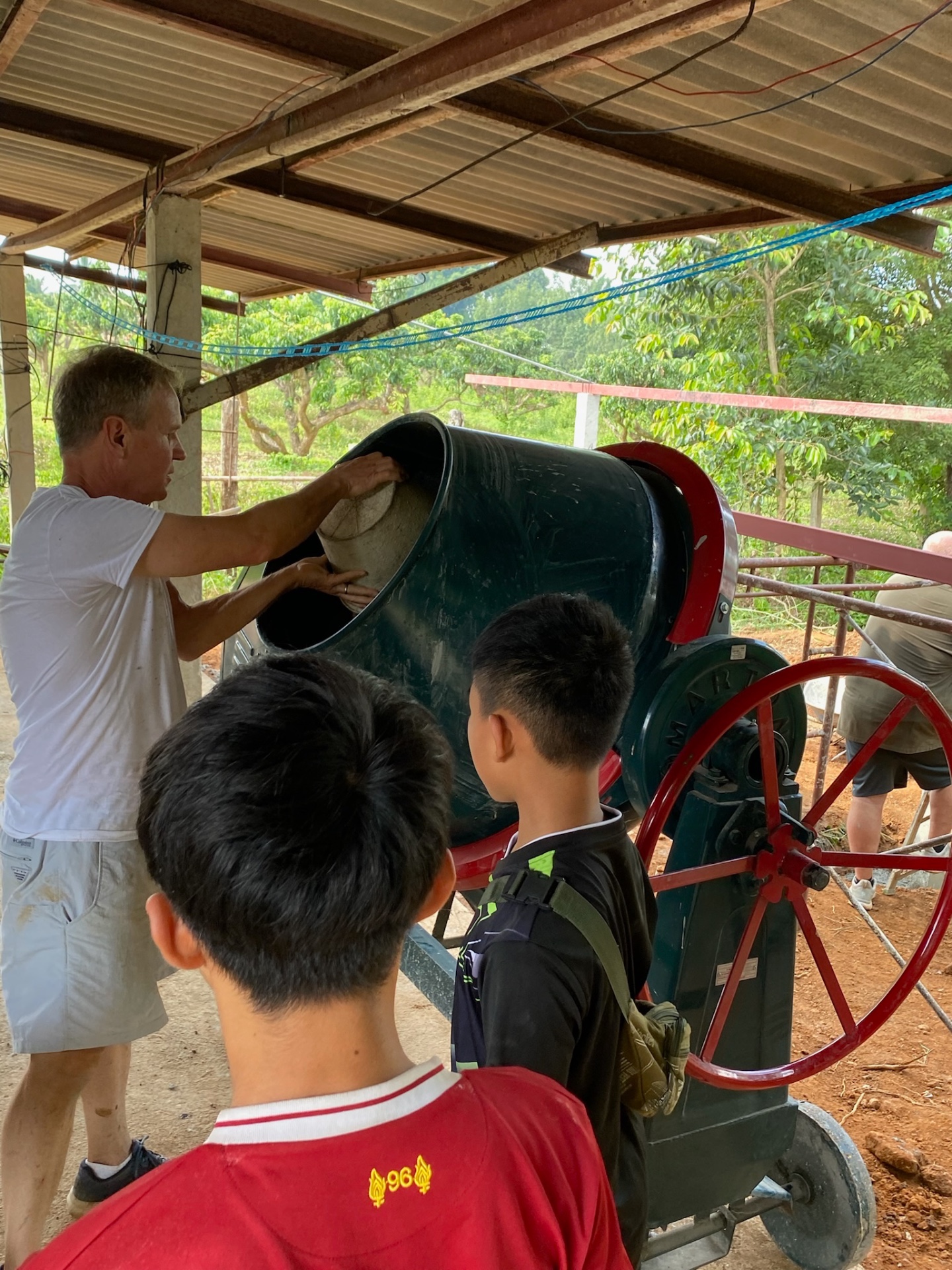 Team member showing students the concrete mixer