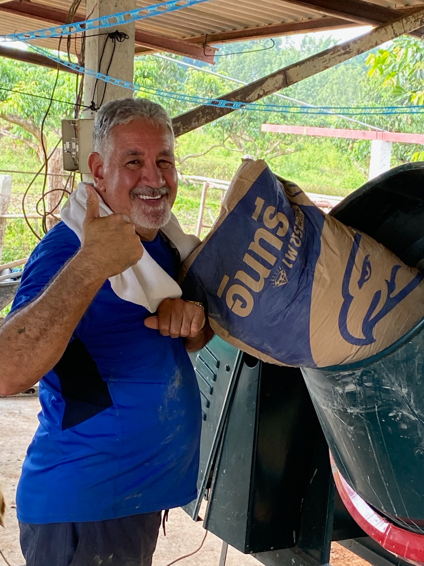 Team member with a bag of cement, thumbs up
