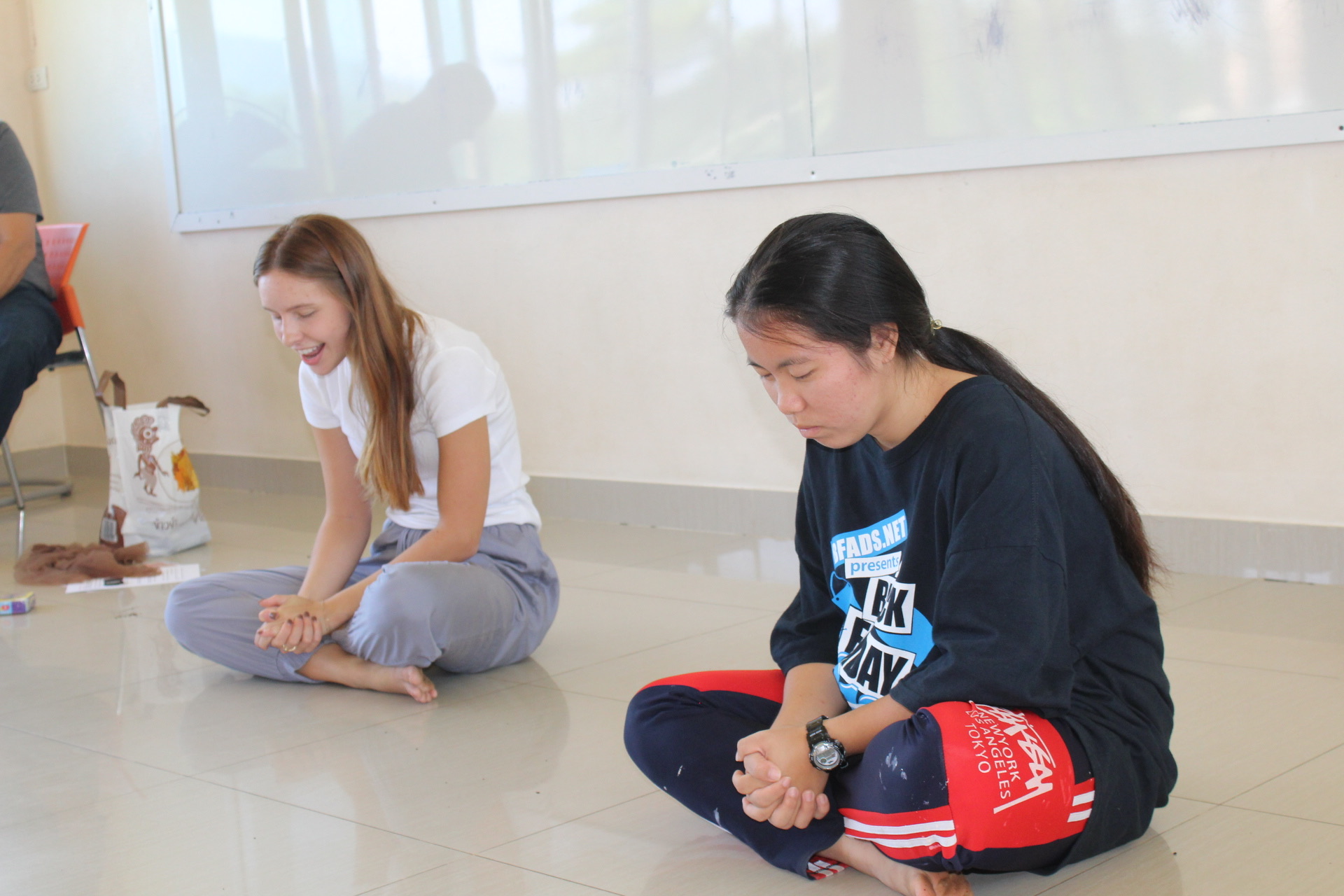 Two women sitting on the floor in conversation