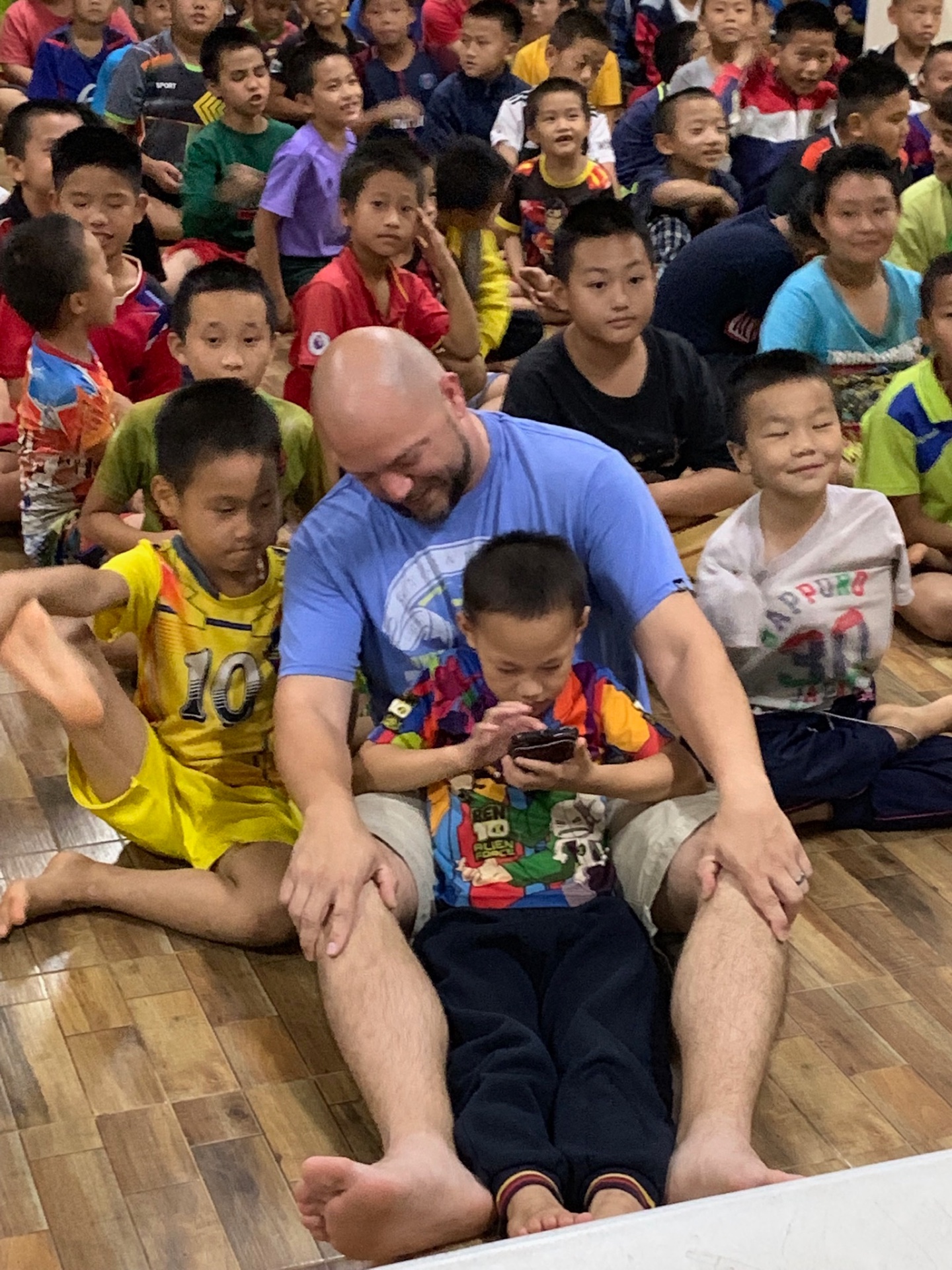 Team member watching a video with a group of boys
