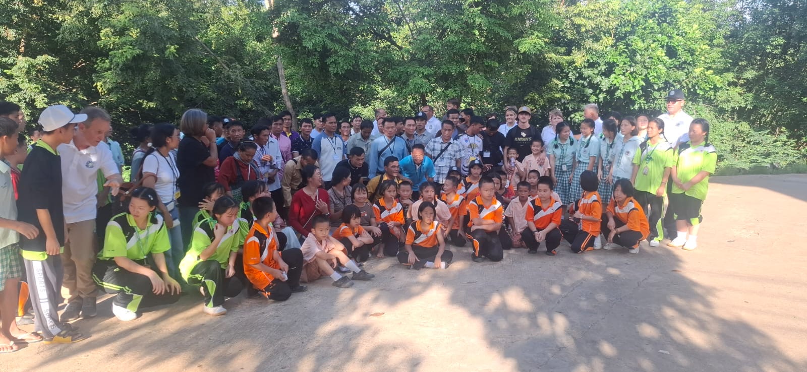 Large outdoor group photo with Laotian pastors, students, and the team